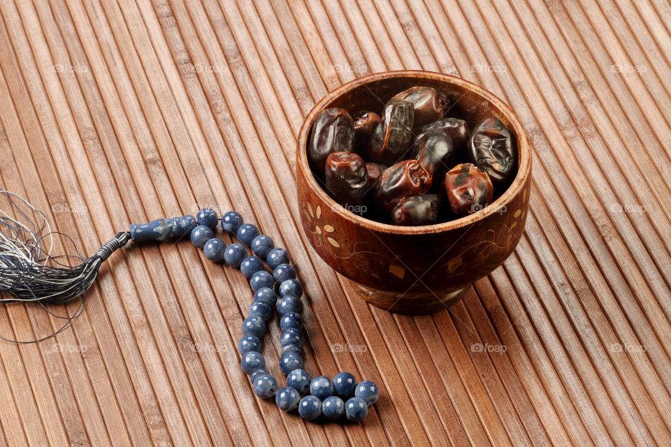 Ramadan Date Fruits and Rosary on a wooden mat