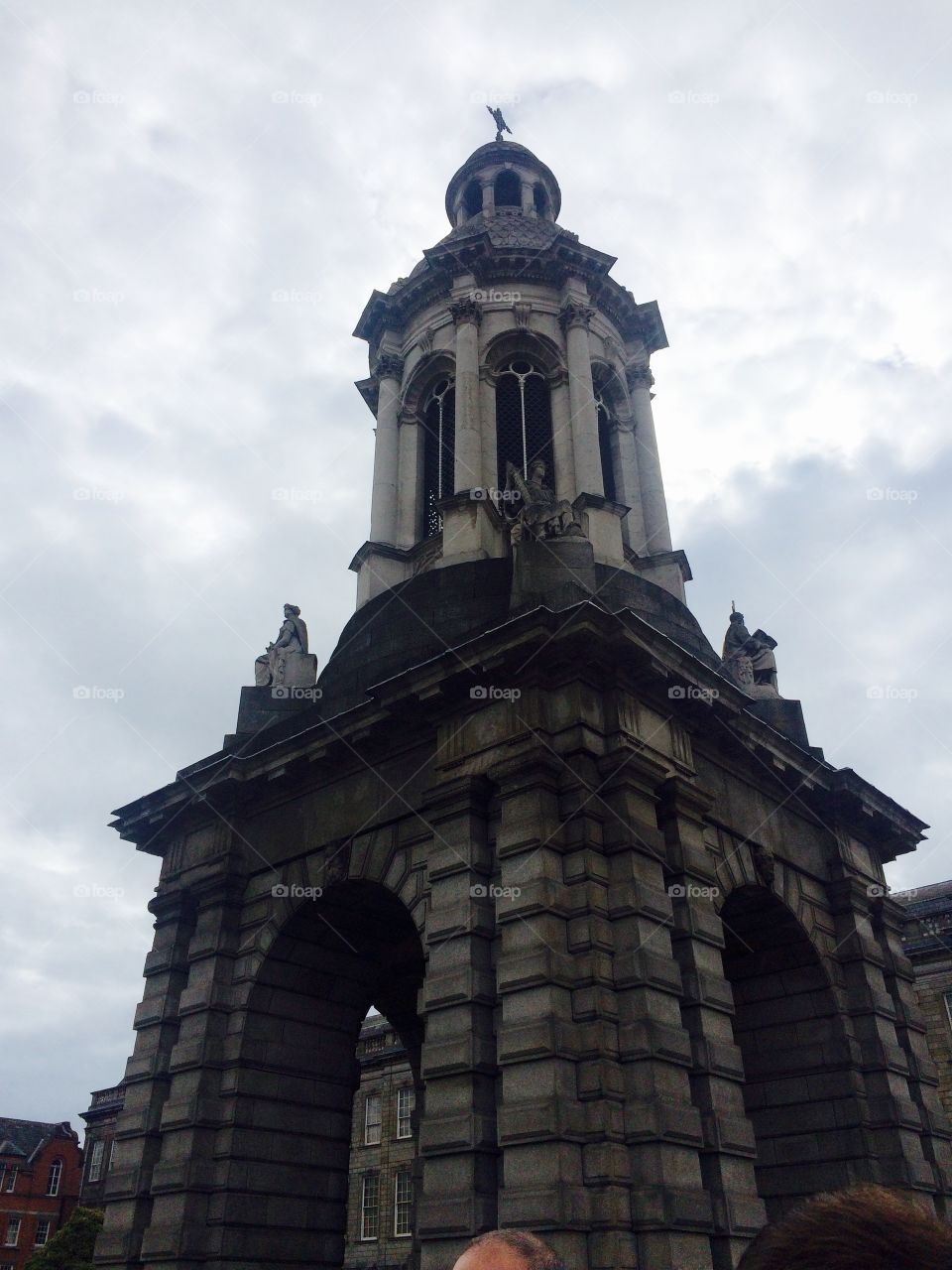 Historical tower and architecture at Trinity college in Dublin Ireland against cloudy Autumn sky 