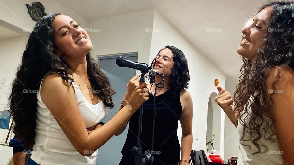 Group of women singing and feeling an emotional song in the karaoke, at the midnight.