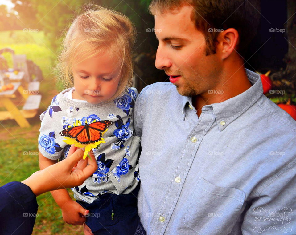 Butterfly wonder. Daddy shows little girl butterfly up close