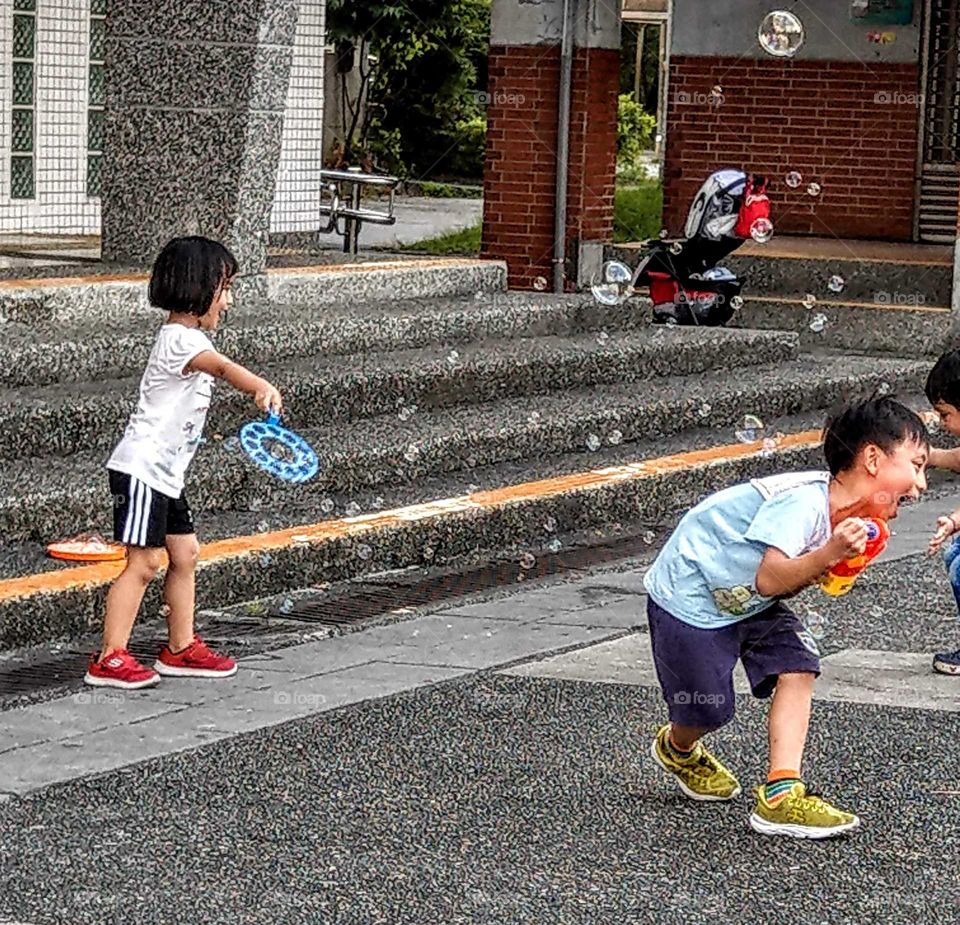 The memories of summer: children were playing with bubbles and water gun very happy during summer vacation.