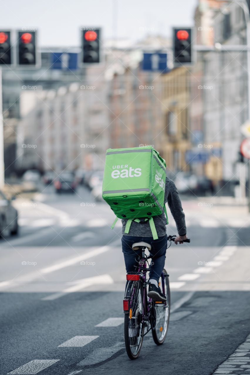 millennial food delivery courier rides a bicycle