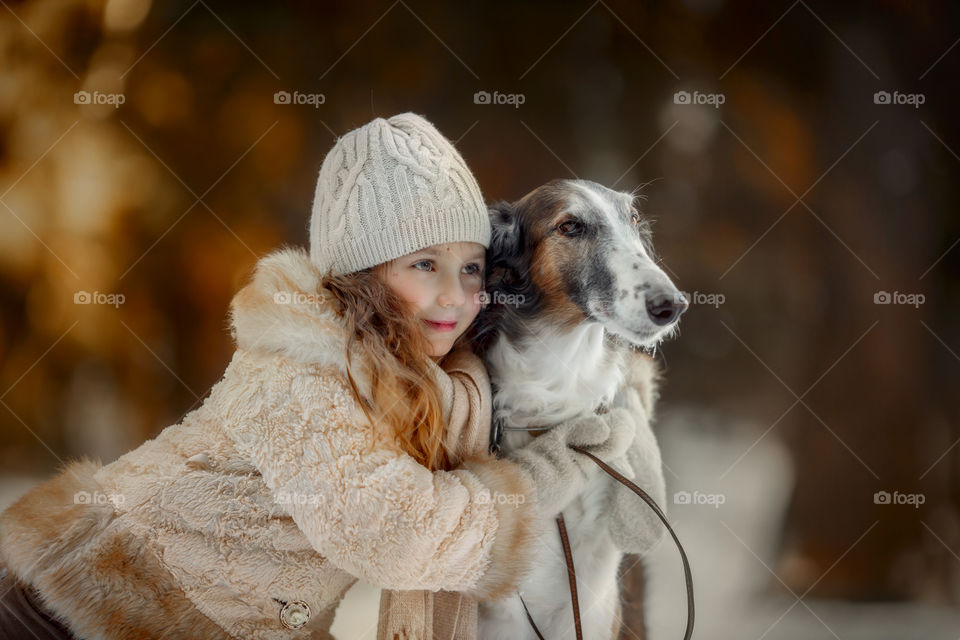 Little girl with dog in autumn park 