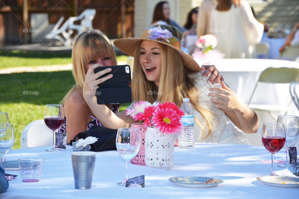 Two cheerful woman looking at mobile phone