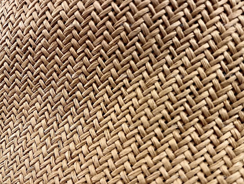 Close up of woven straw hat in colour creating a warm image suitable as a background