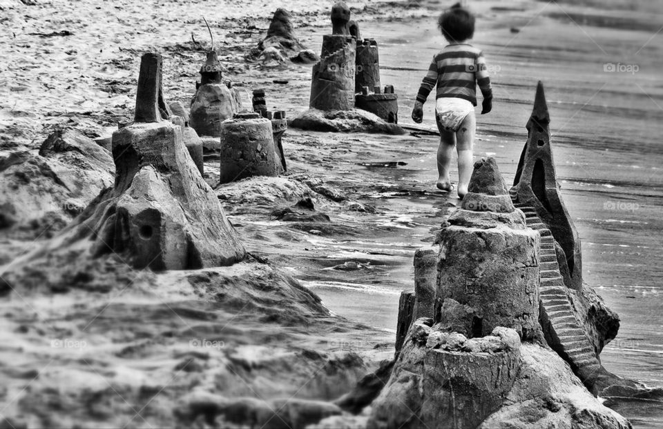 Boy walking through a surreal dreamscape of sand castles