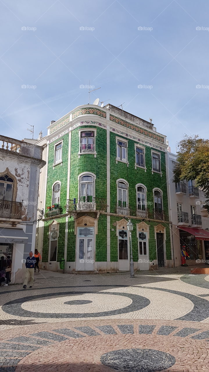 A beautiful city center in Lagos Portugal. A building covered with green tiles just catches your attention!