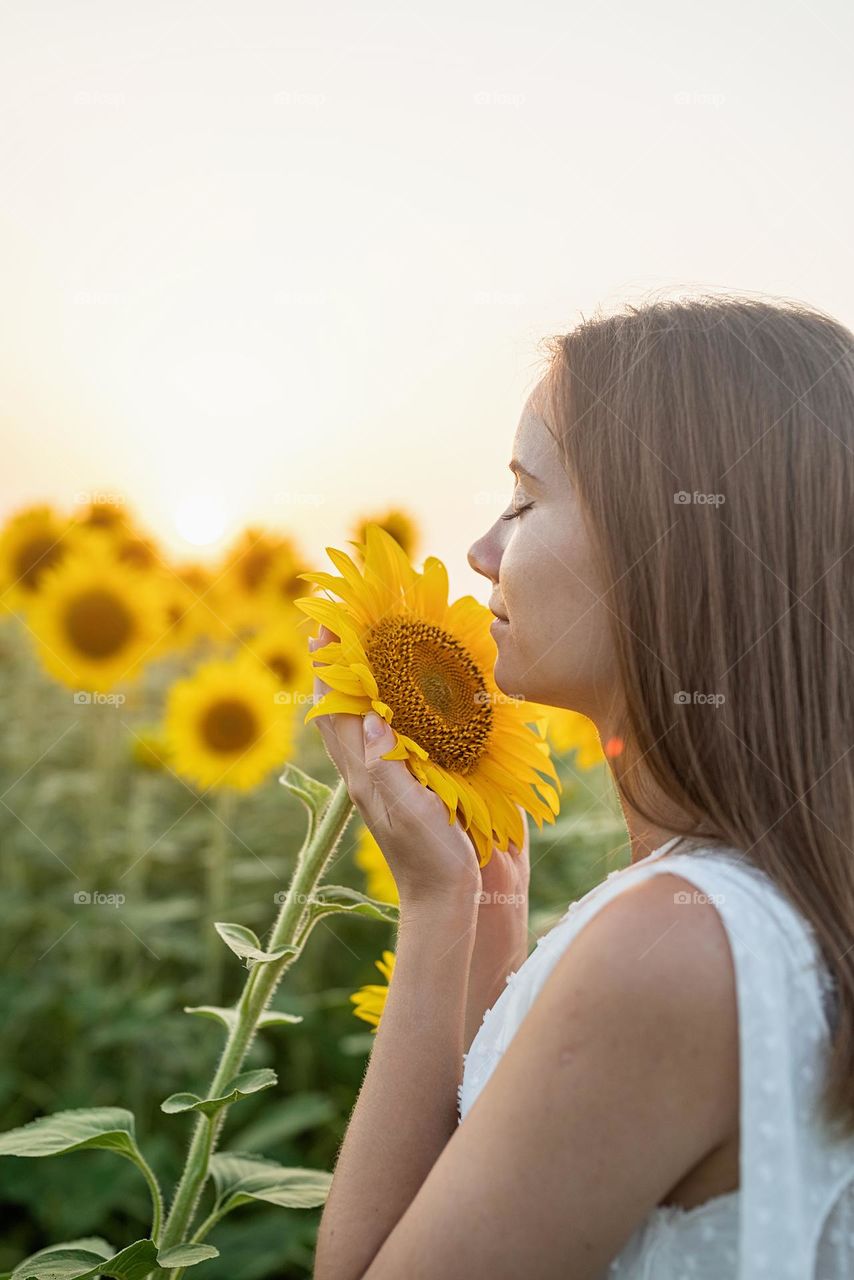 woman smelling sunflower