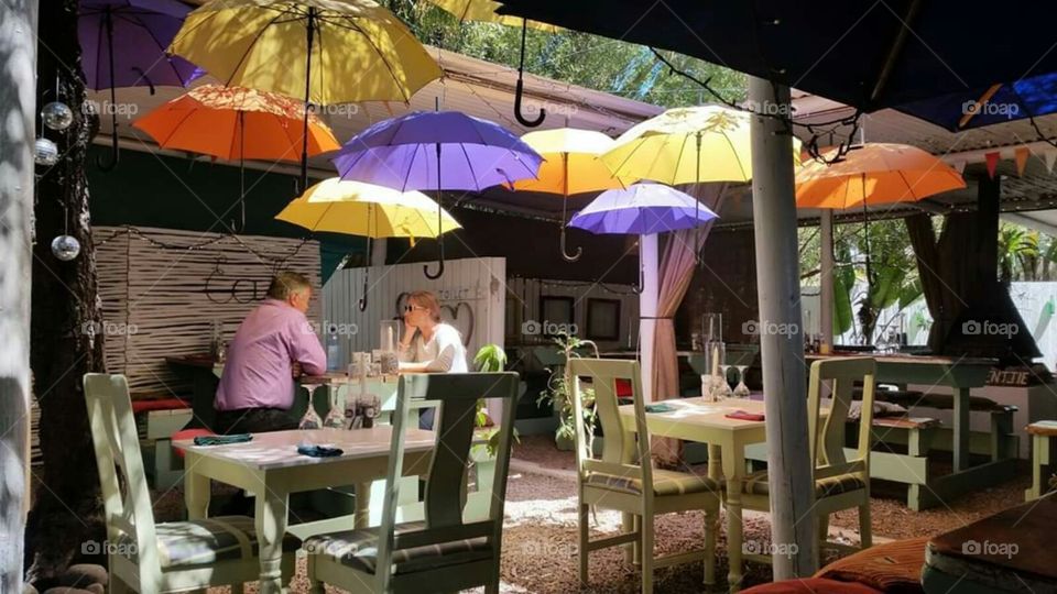 a very cute restaurant that has colourful umbrellas hanging from the roof