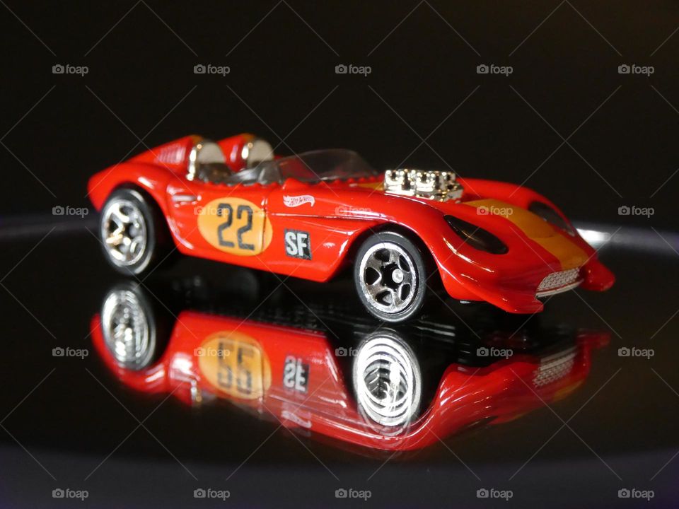 A photo of a red hot wheels toy car