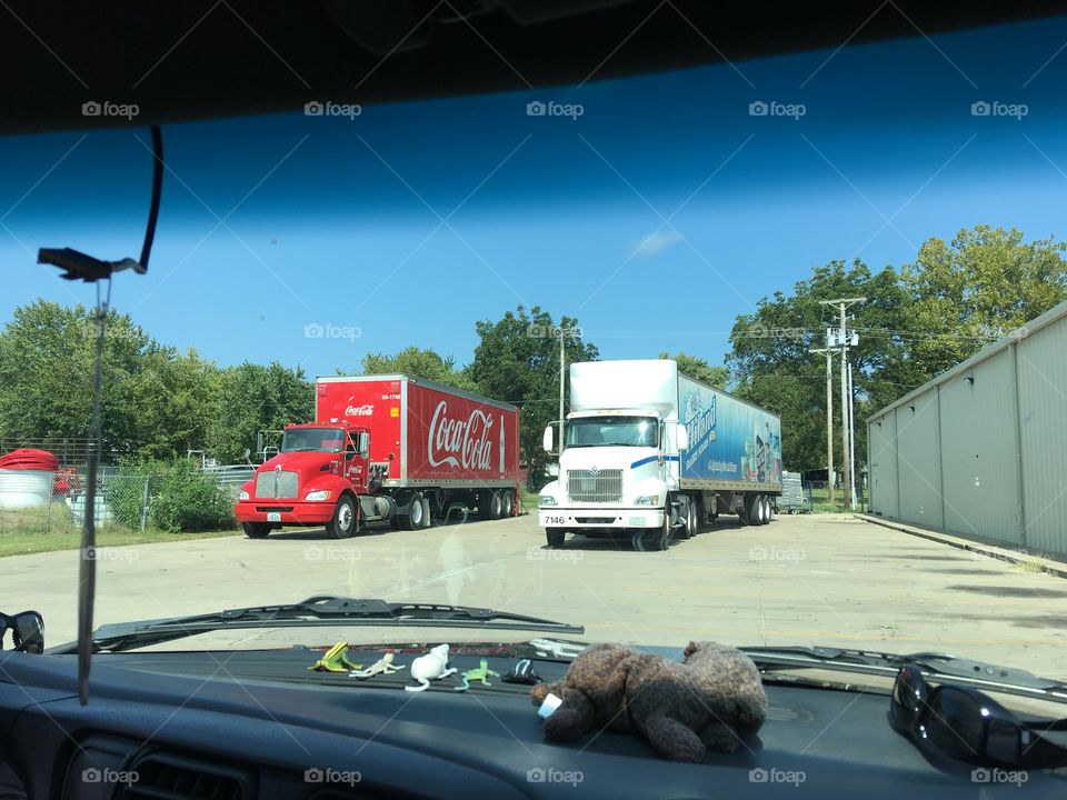 Two trucks delivering there products at the dollar general store today in our town.