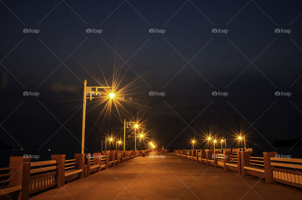 The lights on the bridge at night Background Sea and island at Prachuap Bay in Thailand.