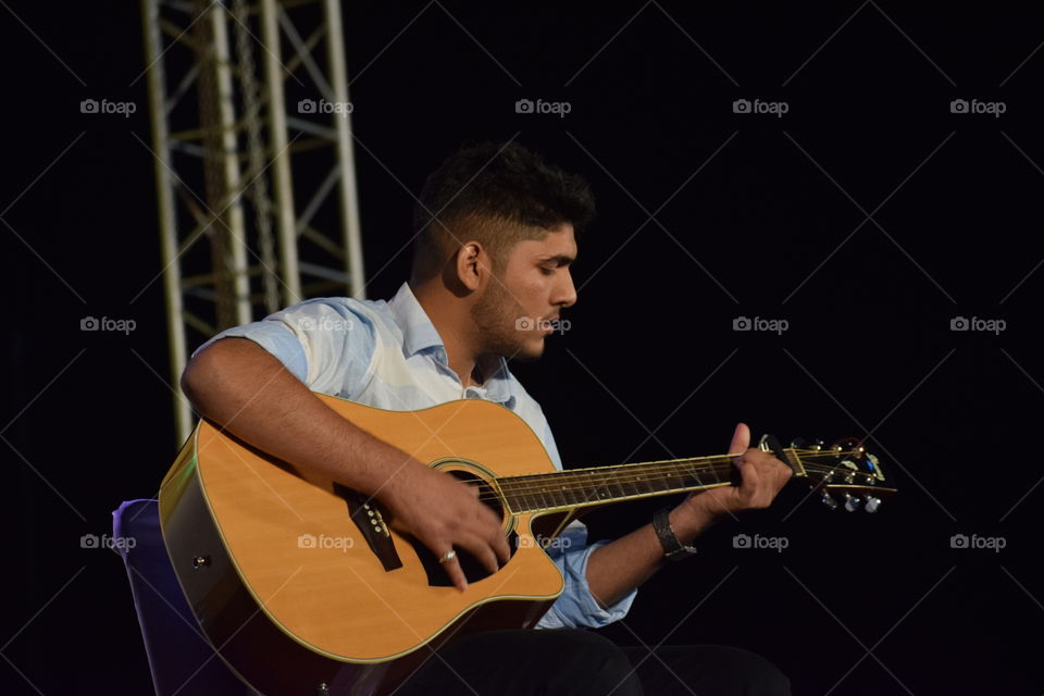 Guitarist playing the guitar... For his love.