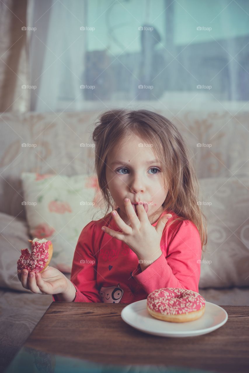 Little girl eating donuts 