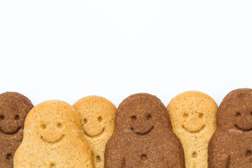 A row of black and white gingerbread men at the bottom of the frame and on a white background representing racial equality, diversity and togetherness.