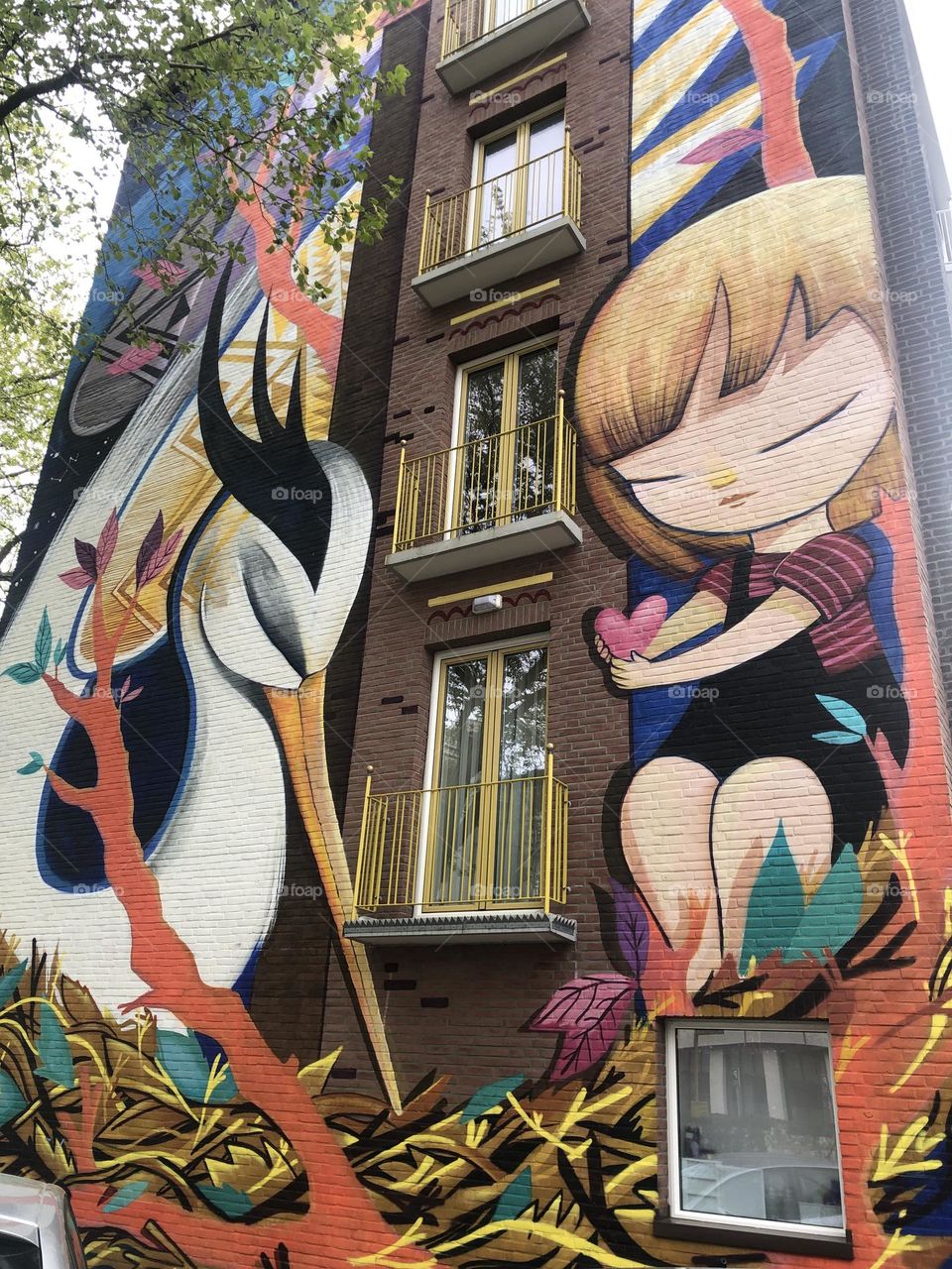 The girl that gives her heart to a crane. Beautiful colors. Emotional mural.