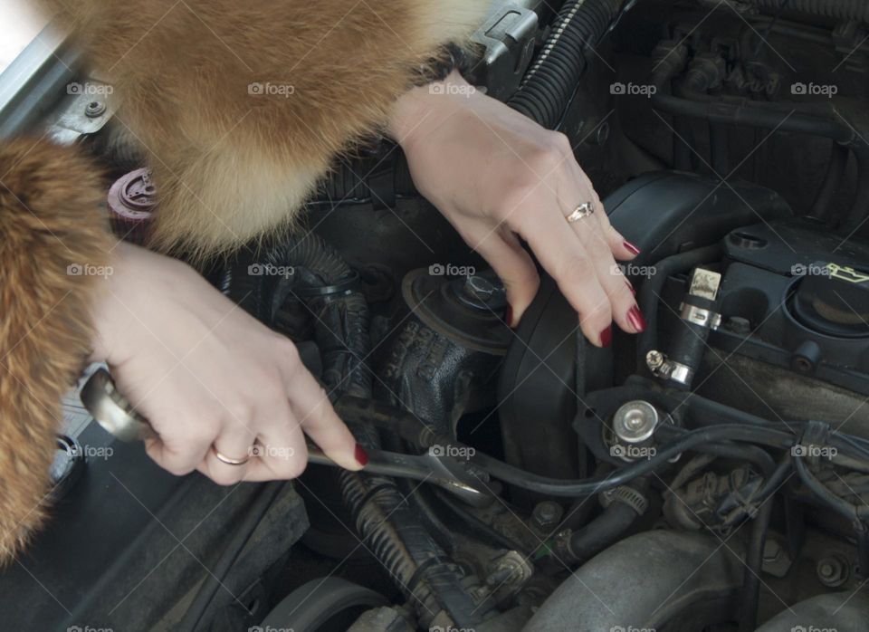 A woman repairing a car