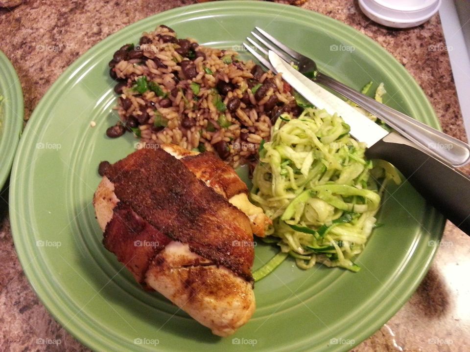 cheese stuffed jalapeno wrapped in chicken and bacon with black rice and beans and zucchini noodles.