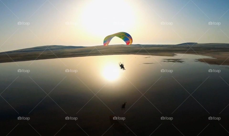 Paraglider flight at sunset