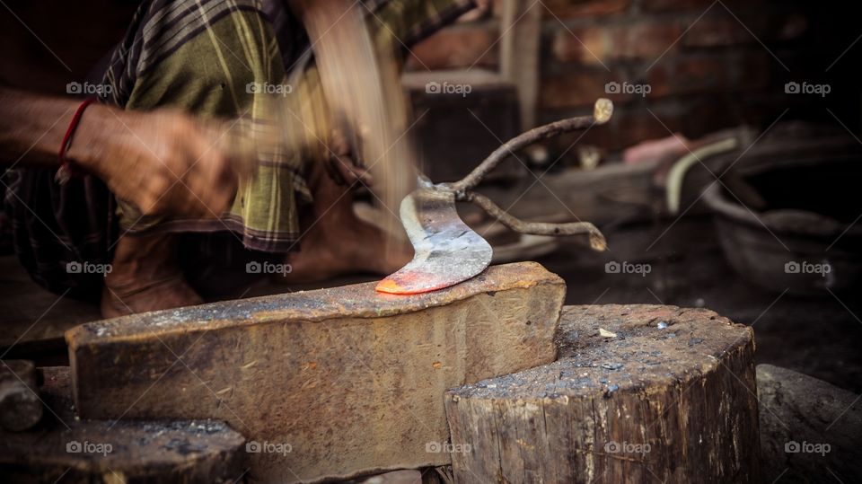 Hardworking blacksmith of Bangladesh making traditional cutting knife. 