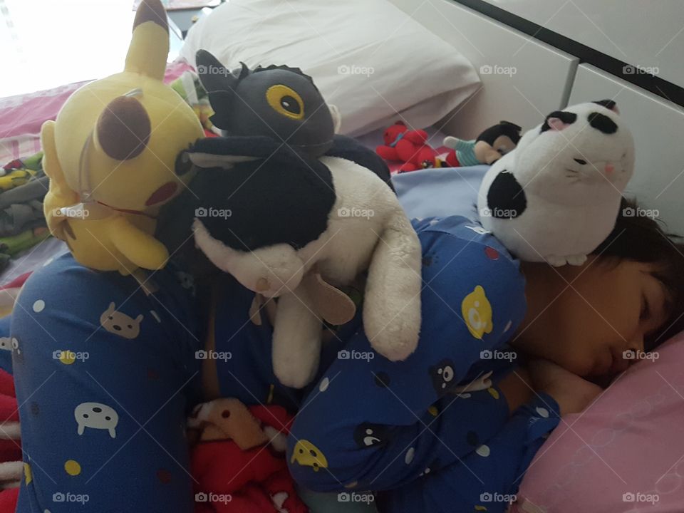 morning on the bed, young boy sleeping with his stuffed animals