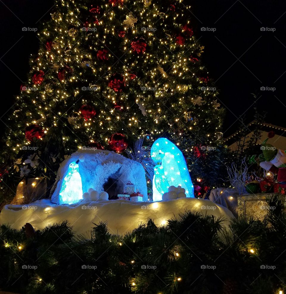 penguins and an igloo with Christmas tree in the background