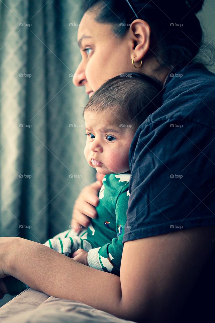 Mother and daughter look out window together, mommy and baby together, mother holds daughter while looking on, quiet moments together 