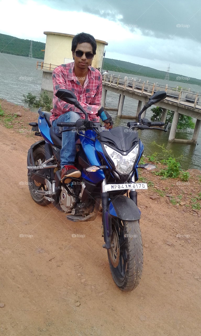 Boy on motorcycle near lake