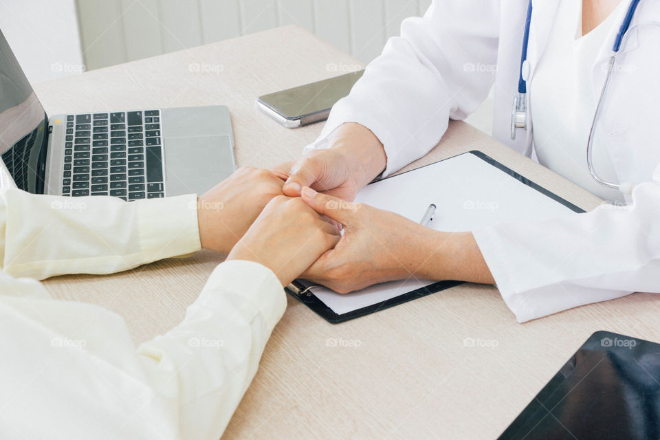 Doctor​ holds​ patient hands to supporting and listening