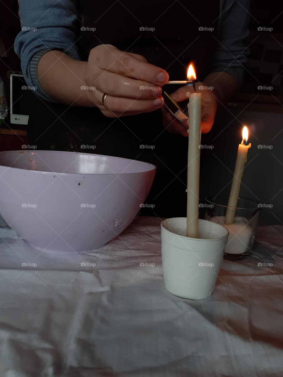 Lighting church candles before preparing Easter bread