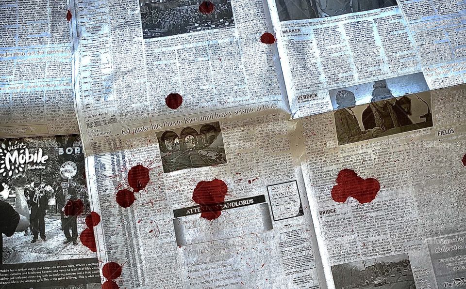 Black and white newspaper contrasted by a bright red blood splatter.