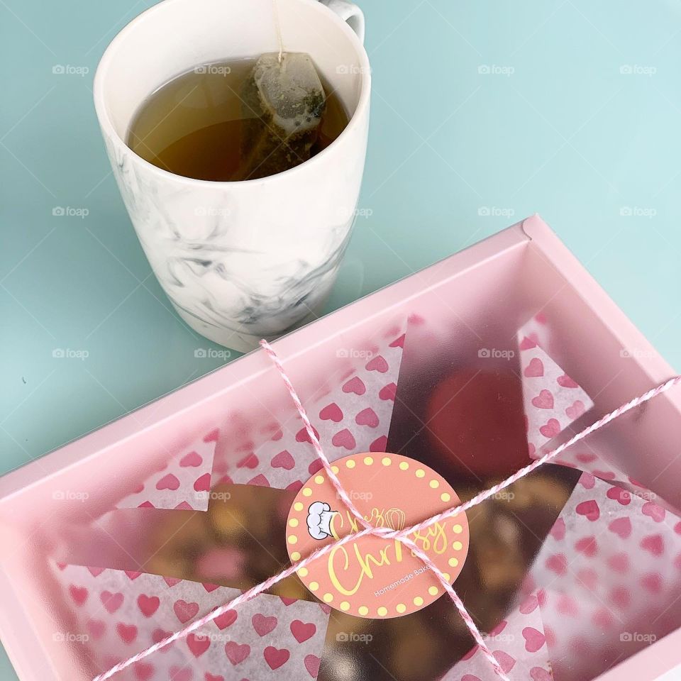 Freshly baked Gooey Easter cookies in a box in chocolate in big chunk with hot tea for afternoon snack 