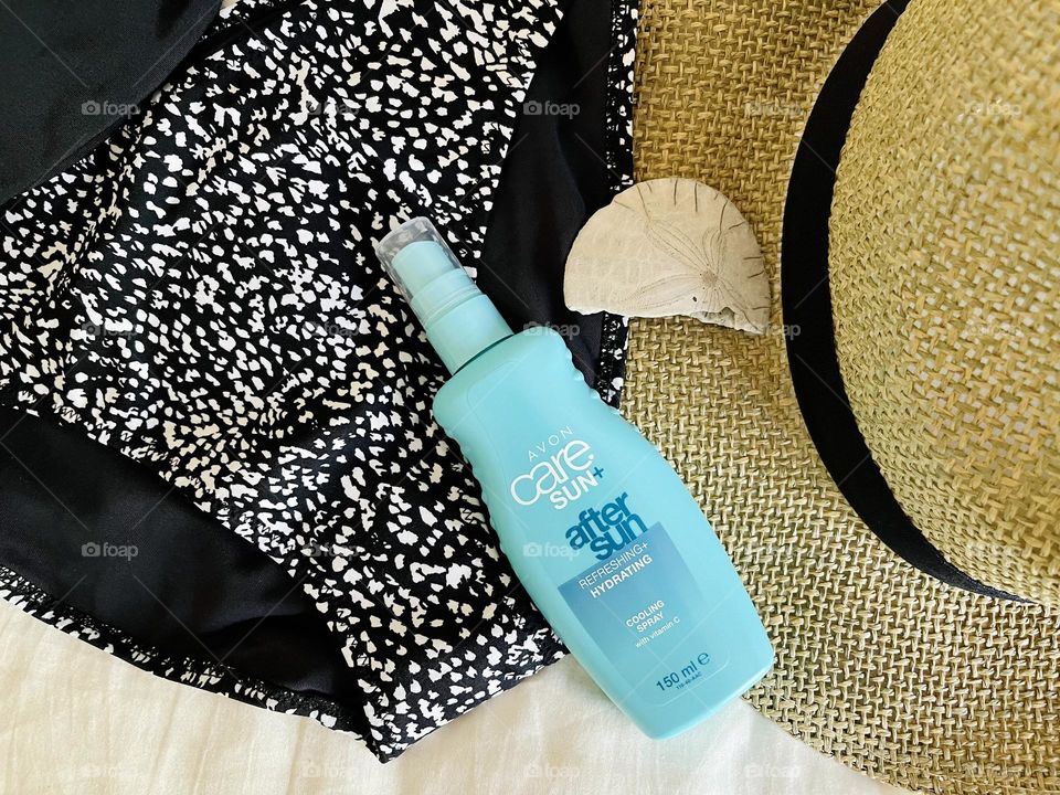 After Sun spray Avon on the swimming suit background 