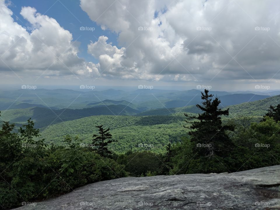 treetop vista over forested valleys at the top of a hiking trail along the Blue Ridge Parkway in North Carolina.