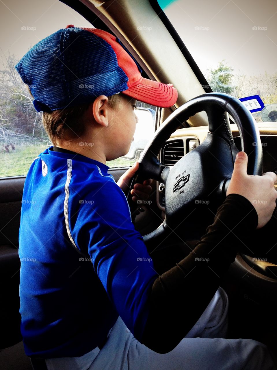 Young driver. 9 year old boy dreaming of driving his dad's truck