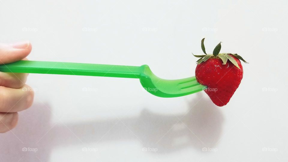 Hand Holding a Strawberry on a Fork