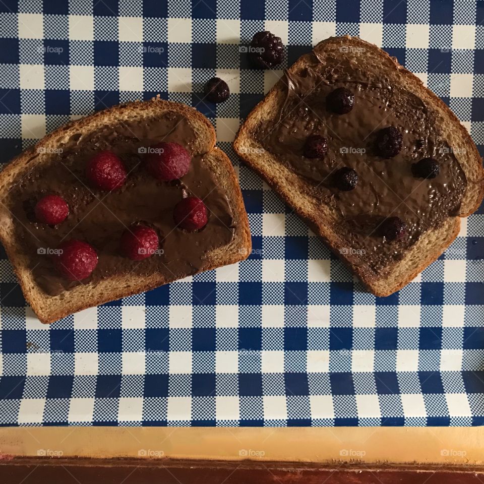 A yummy chocolate Nutella sandwich with blackberries and raspberries displayed on a blue and white checkered serving tray. USA, America