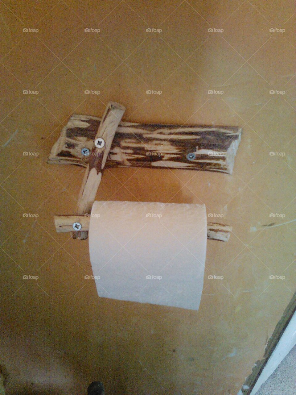 toilet paper holder. i made this out of sticks an logs.