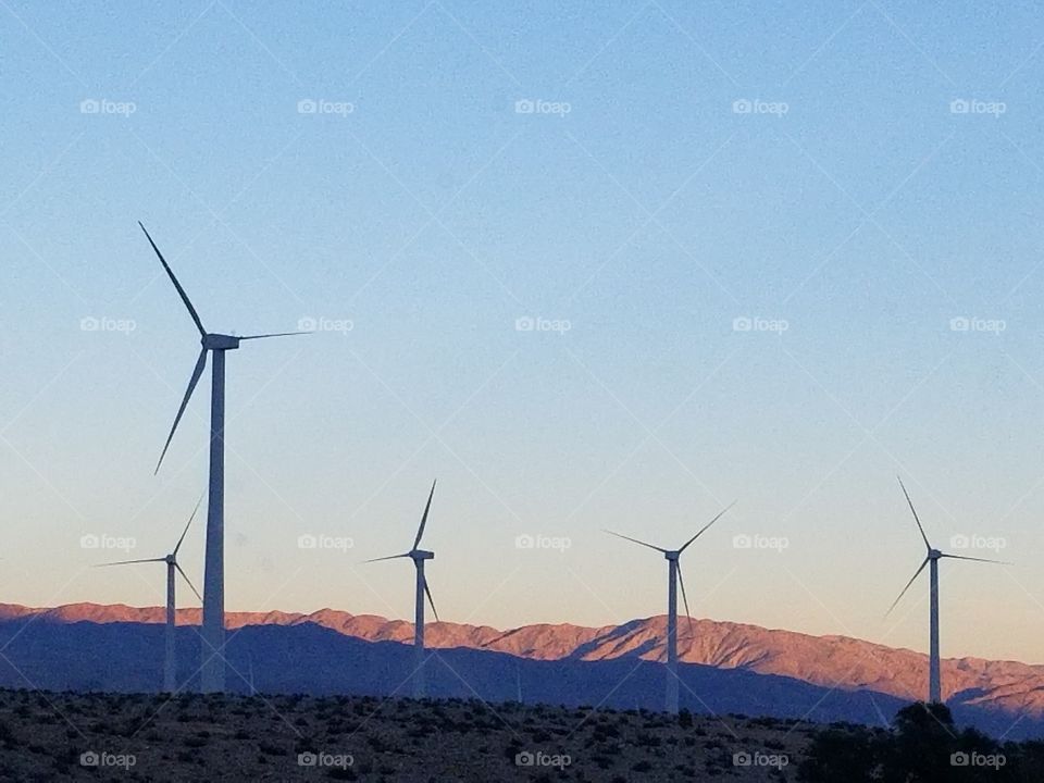 Wind turbines with a backdrop of desert hills