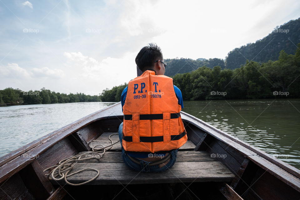 Male tourist sitting on the front of the boat