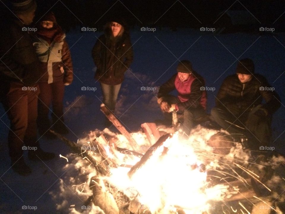 Friends bringing in the new year around the fire in the snow of Chautauqua, NY