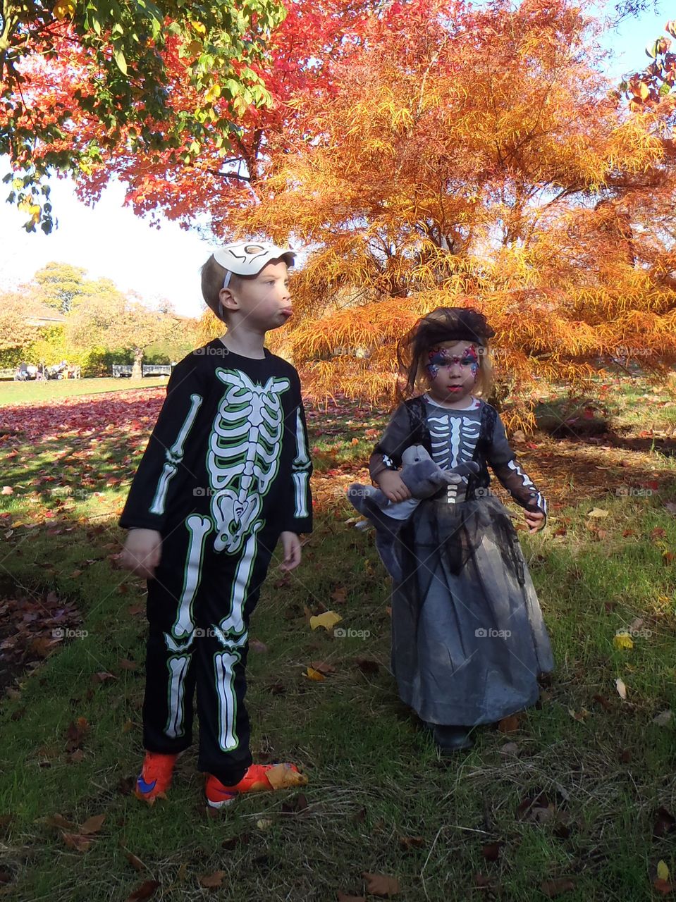 Children in Halloween costume in park during autumn