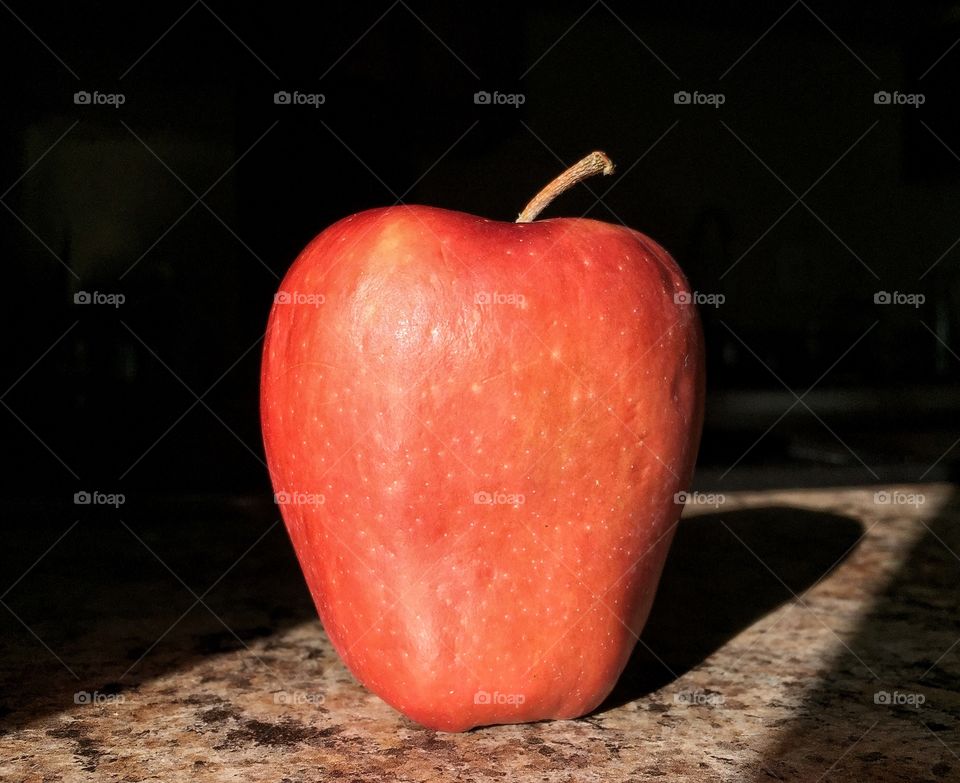 Ripe red apple in afternoon sun