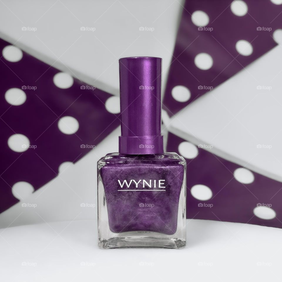 Purple nail polish, against a background of purple & white bunting