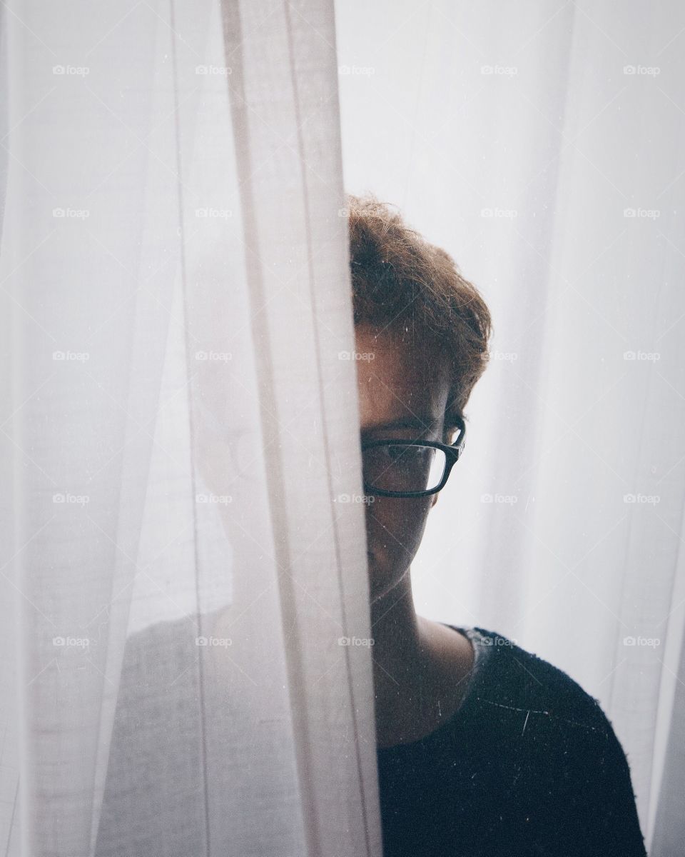 Man behind standing curtains