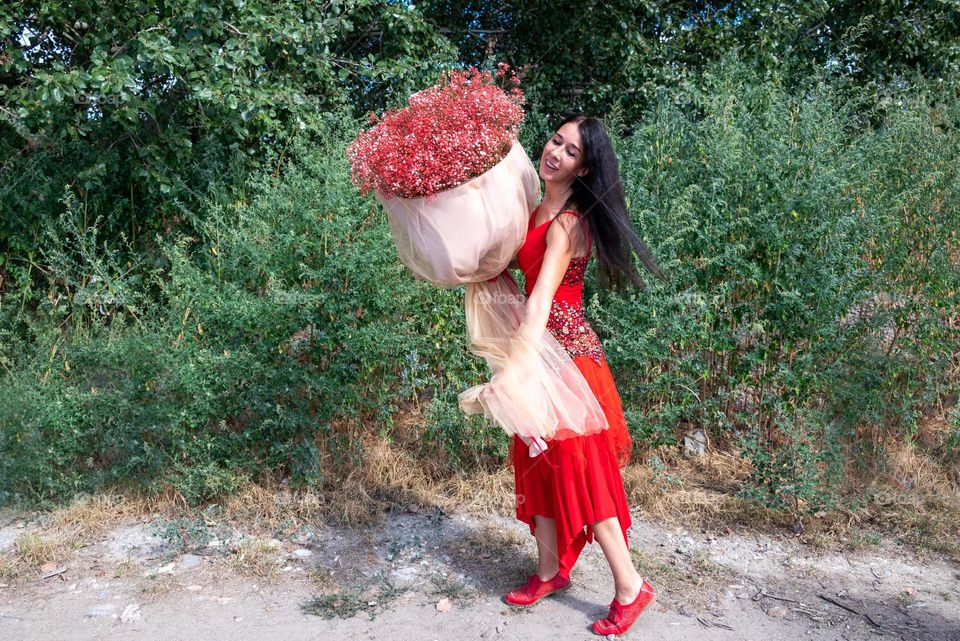 Woman Dances with a Large Bouquet of Red Flowers