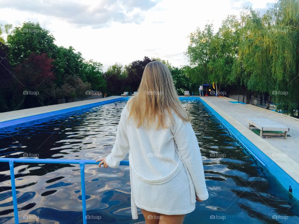 Rear view of a woman standing at pool side