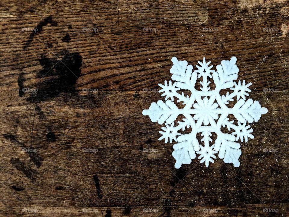 single snowflake on a wooden table