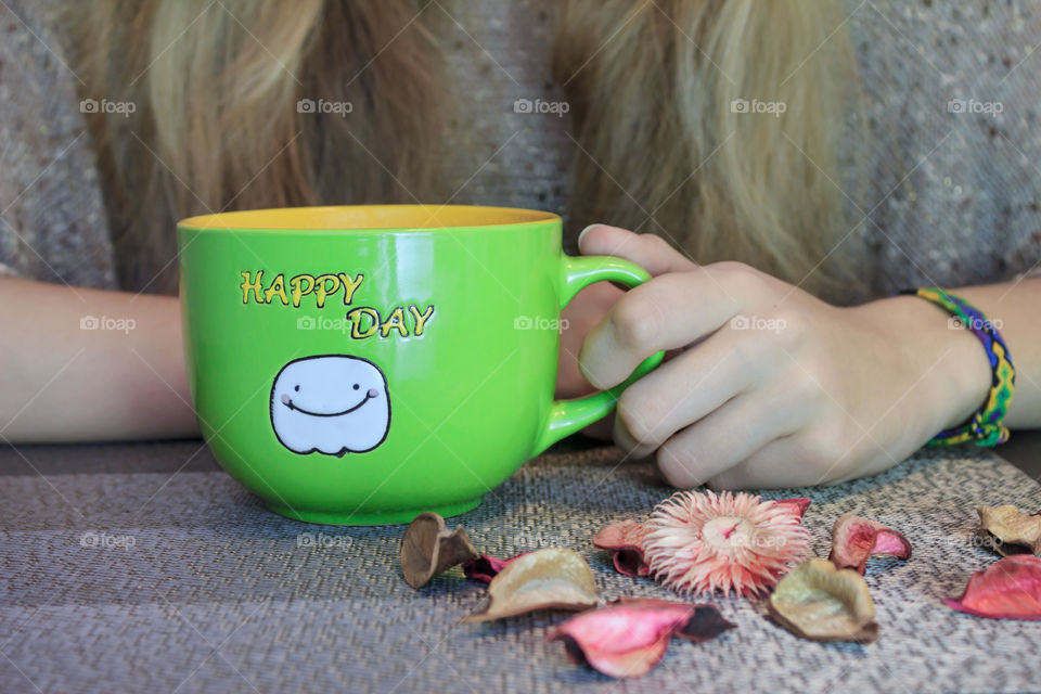 cup of hot tea in the hands of a girl