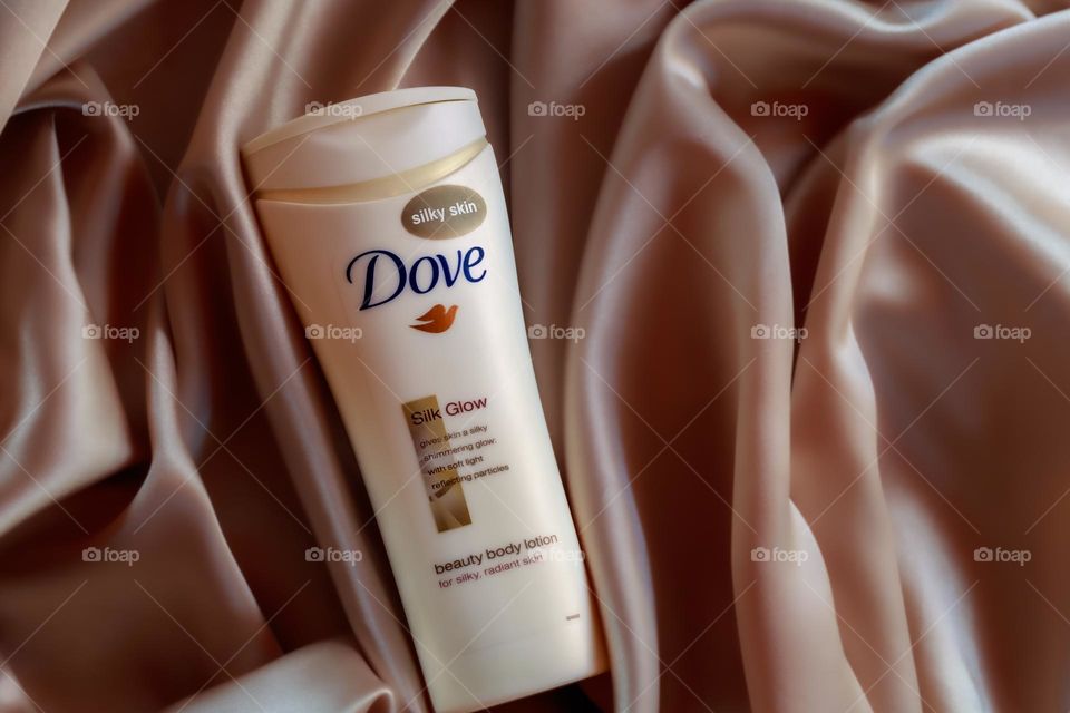 Dove Silk Glow displayed on a rose gold, silky fabric